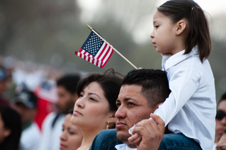 女孩用美国国旗坐在父亲肩上